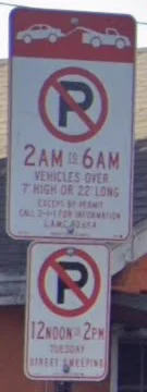 A no parking sign that applies only to vehicles over 7 feet high or 22 feet long, 2am to 6am, above a Tuesday sweeping panel.